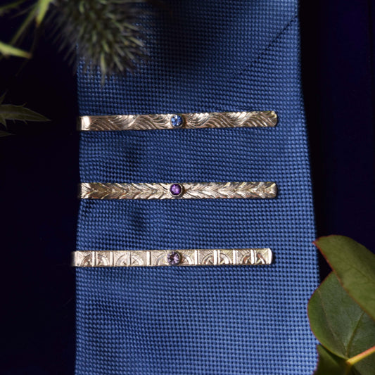 Tie pin with gemstone and hand-engraved pattern