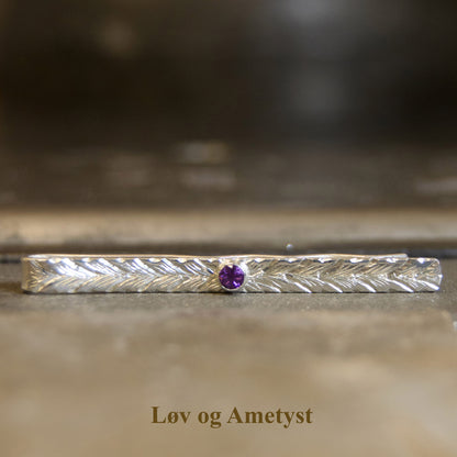 Tie pin with gemstone and hand-engraved pattern